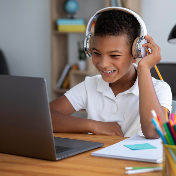 little boy doing school online